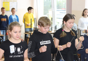Uczniowie klasy 7b grają na instrumentach perkusyjnych.